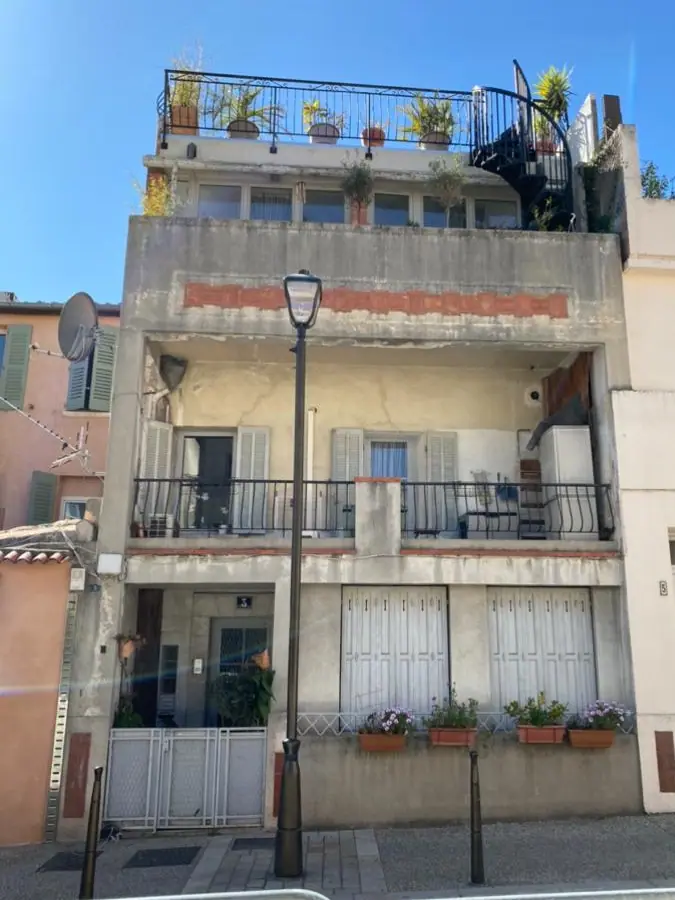 Façade de maison de ville décrépie avant ravalement, enduit cloqué et bandeau de briques rongé — Castagne Couverture
