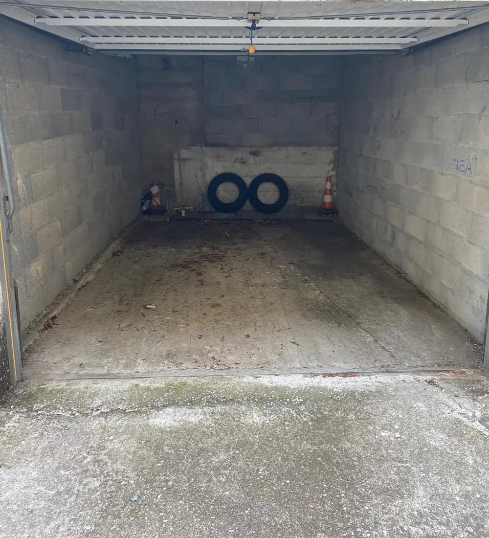 Garage aux murs en parpaings bruts et dalle béton tachée avant rénovation — Castagne Couverture
