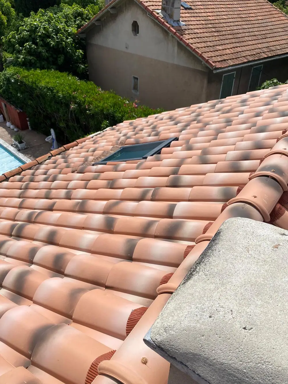 Vue plongeante sur une couverture neuve en tuiles canal, fenêtre de toit centrée