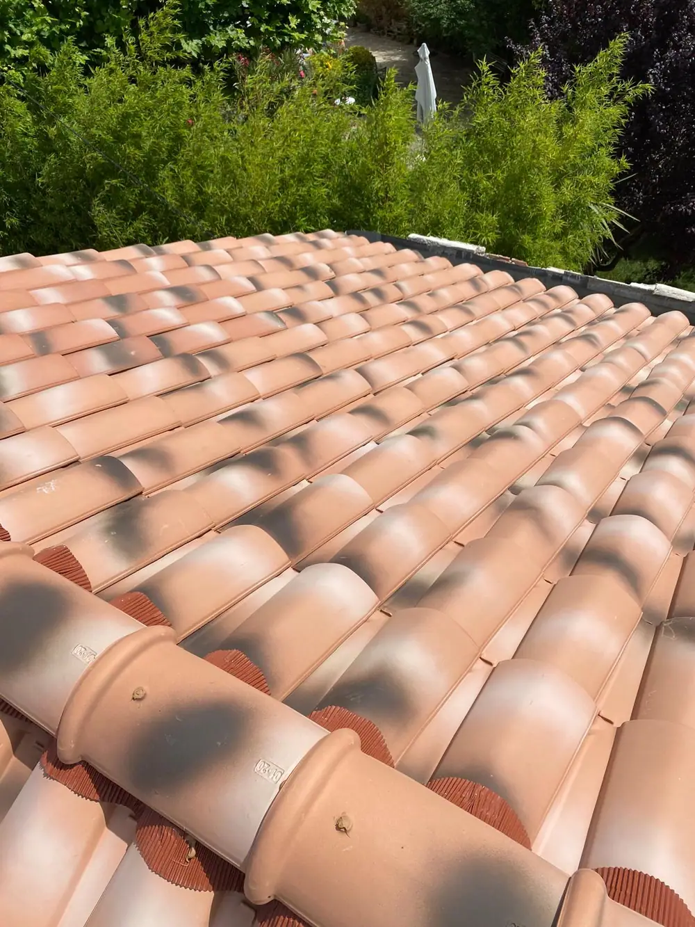 Gros plan sur des tuiles canal neuves et le faîtage scellé sur closoir ventilé