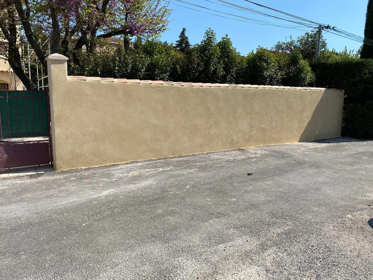 Mur de clôture enduit à neuf avec couvertine en tuiles canal