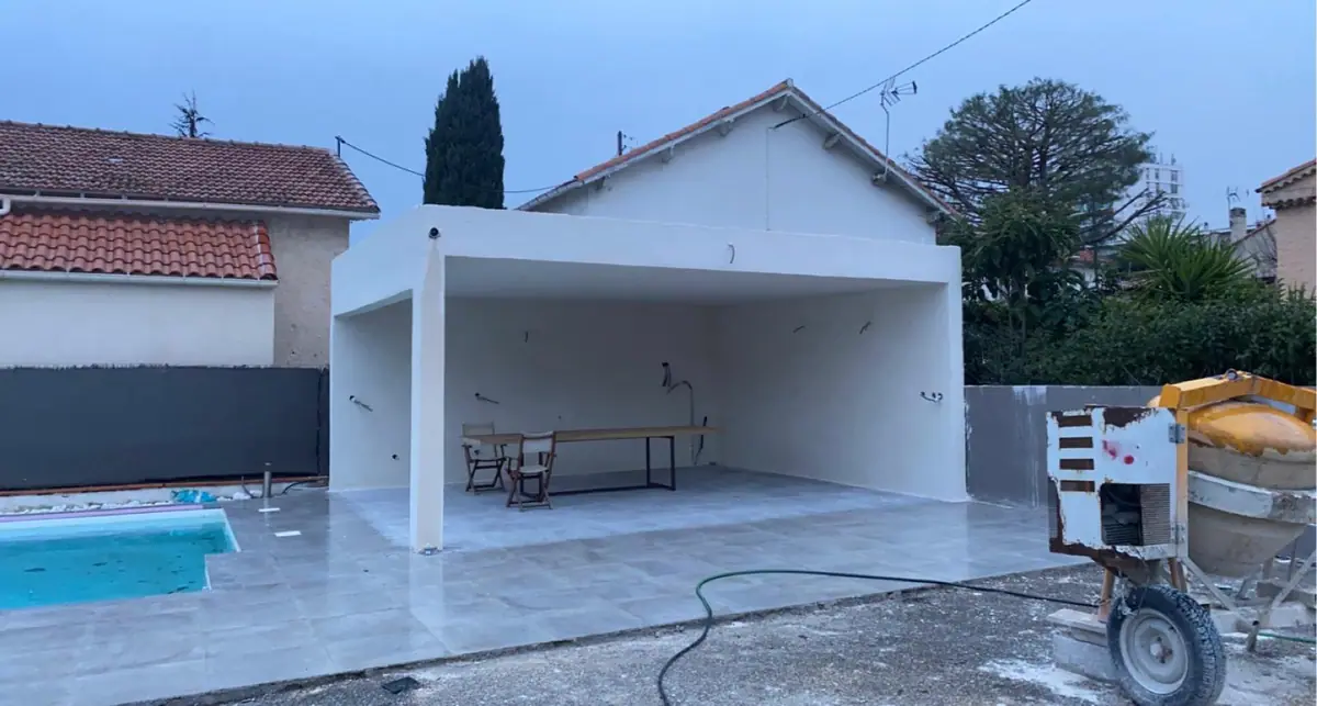 Cuisine d’été maçonnée au bord d’une piscine, structure en béton enduit blanc