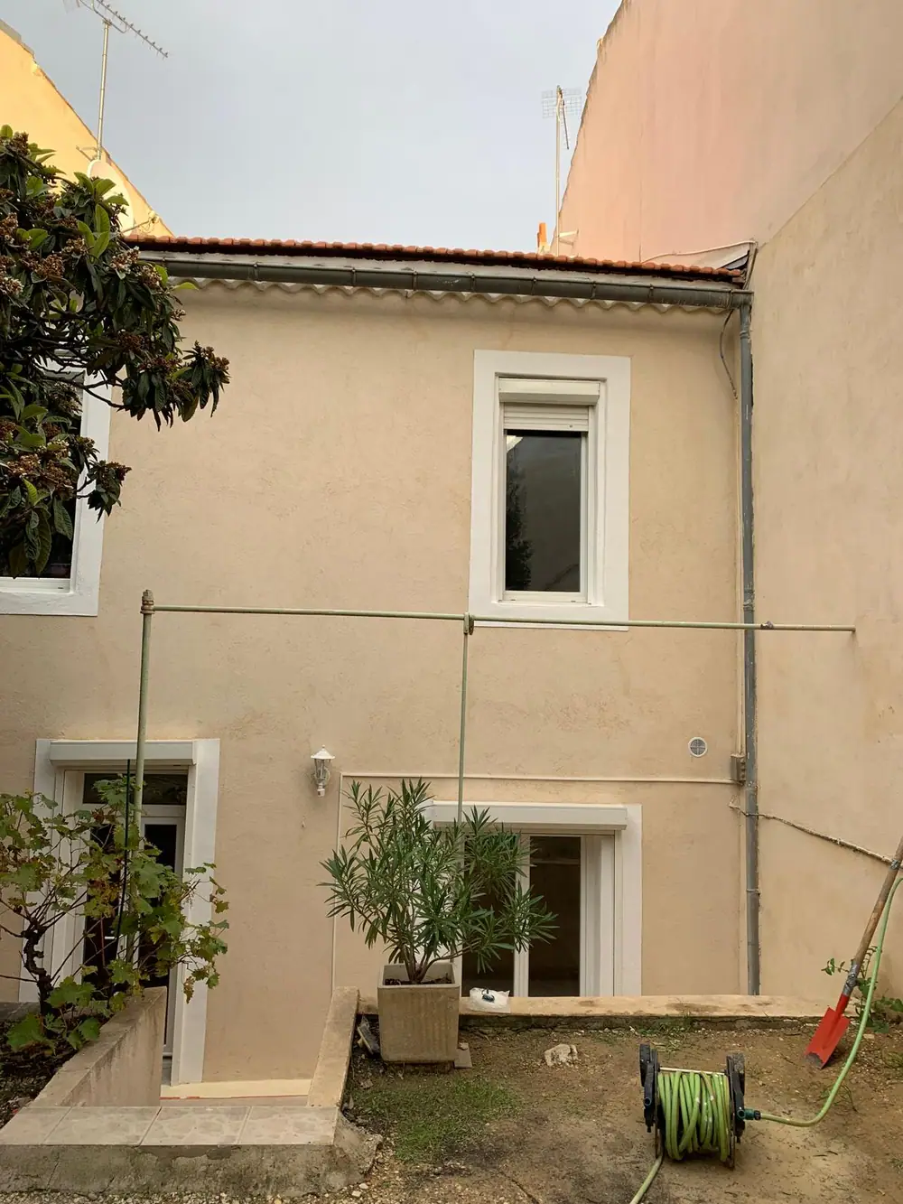 Façade sur cour terminée, enduit taloché teinté dans la masse