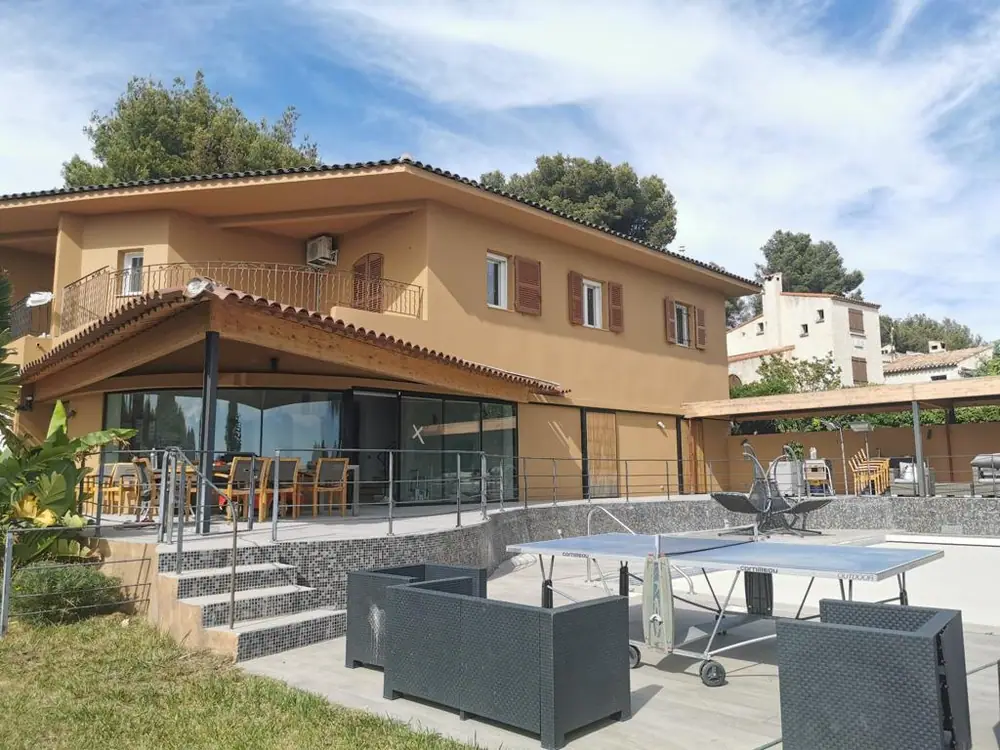 Villa en enduit ocre avec auvent sur charpente bois couvert en tuiles, terrasse et balcon en fer forgé — Castagne Couverture